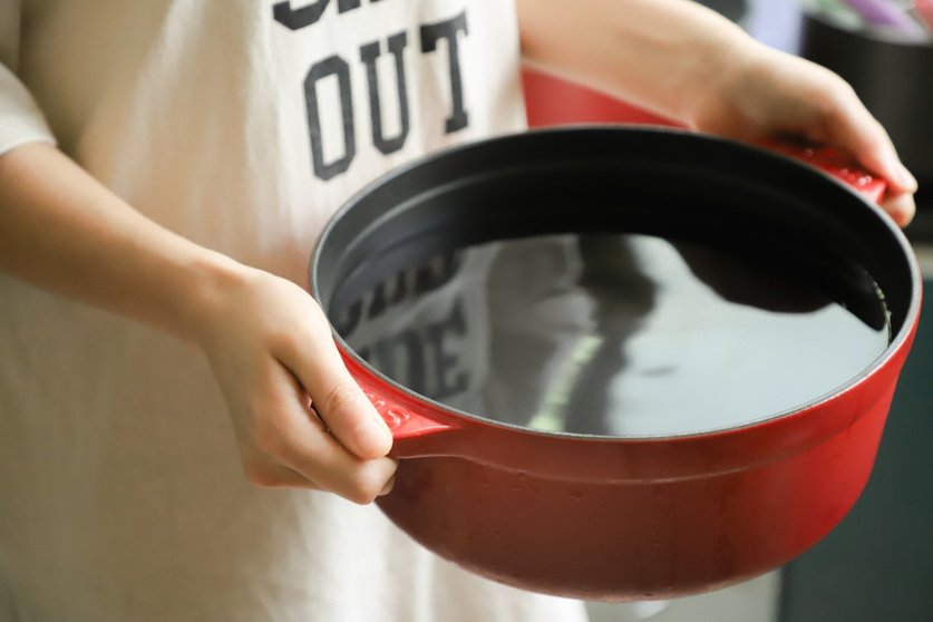 person-holding-red-pot-filled-with-water-1204251
