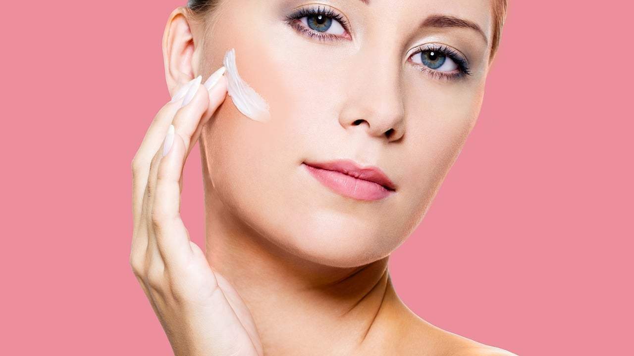 Mujer aplicando crema en el rostro